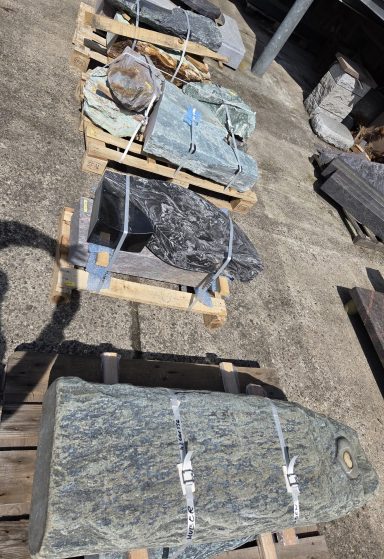 Verschiedene Steinblöcke auf Paletten, verpackt und gesichert.