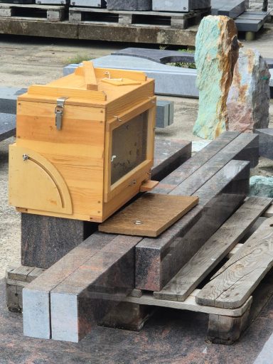 Holzkasten auf einem Stapel aus verschiedenen Materialien, umgeben von Baustellenmaterialien.