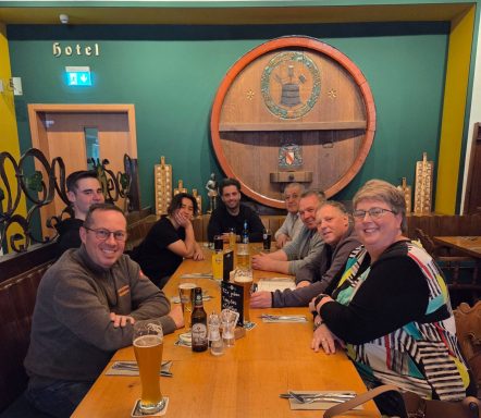 Eine Gruppe von sieben Personen sitzt an einem Tisch in einem Restaurant mit Getränken.