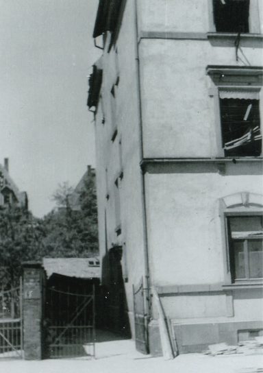 Eine verlassene, verwitterte Gebäudeansicht mit beschädigten Fenstern.